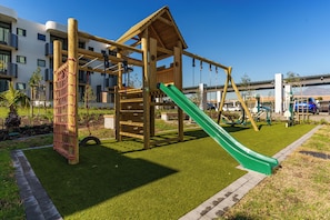 A playground with a slide and climbing structures. - Romantic Century City Hideaway | Balcony and Views (Cape Town)