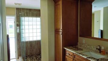 A kitchen with wooden cabinets, a marble countertop, and a large window.