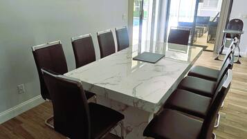 A conference room with a marble table and black chairs, large windows, and a view of the outdoors.