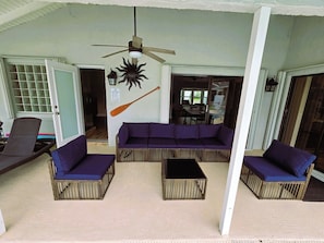 A covered outdoor seating area with a ceiling fan, a wall-mounted bat decoration, and a pool rules sign. - Luxury private Wellington Heated Pool Equestrian (Wellington)