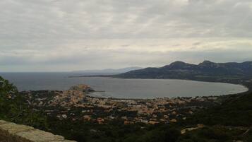 Une ville côtière offrant une vue sur la mer et les montagnes au loin.