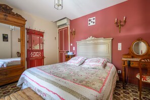 Une chambre à coucher avec un lit, une commode, un miroir et une armoire.