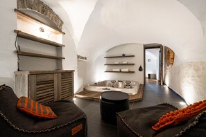 A spa room with a wooden bench, a black trash bin, and a hot tub. - Le Refuge du Bez - Pistes de ski à 100m (La Salle-les-Alpes)