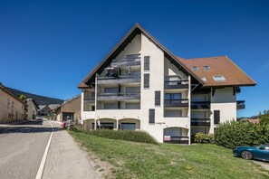 Ein mehrstöckiges Gebäude mit geneigtem Dach, Balkonen und einem Schild, das einen Ausverkauf anzeigt.