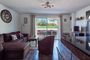 Ein modernes Wohnzimmer mit einer Couch, einem Esstisch und einem Fernseher.