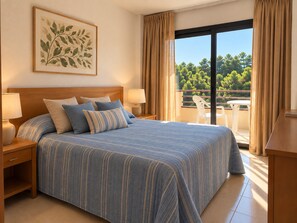 Ein Hotelzimmer mit einem großen Bett, zwei Nachttischen, einem Fenster mit Vorhängen und Blick auf Bäume.