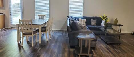Una sala de estar con una mesa de comedor, sofá y una mesita auxiliar.