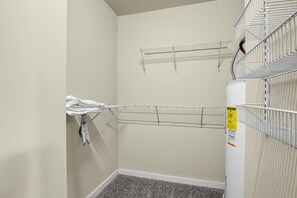 A laundry room with two metal drying racks, a white wall, and a carpeted floor. - Game Day Getaway Near Texas A&M with Pool (College Station)