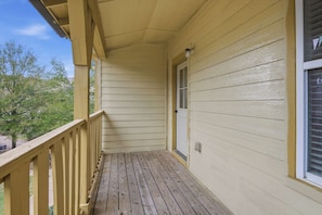 A covered porch with wooden decking and a yellow exterior wall. - Game Day Home Base with Pool and Near Texas A&M (College Station)