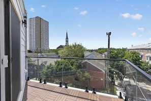 A balcony with a view of a church steeple and residential buildings. - Queen Village Grand | 3BR, Rooftop & Garage (Philadelphia)
