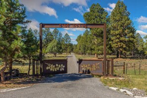 A wooden gate with 'Pine Grove' written above it, leading to a gravel path surrounded by pine trees. - New! Private 40-Acre Retreat | Sneffels Mtn Views | 10 Minutes to Ridgway (Ridgway)