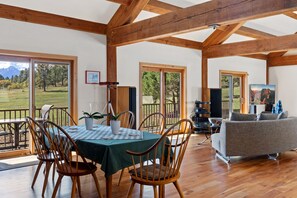 A spacious room with a dining table, chairs, a sofa, and a television. - New! Private 40-Acre Retreat | Sneffels Mtn Views | 10 Minutes to Ridgway (Ridgway)