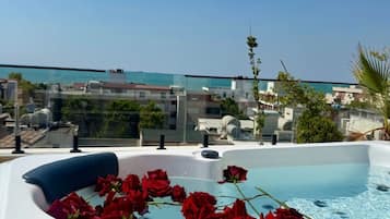 A rooftop pool with red roses and a clear view of the cityscape.