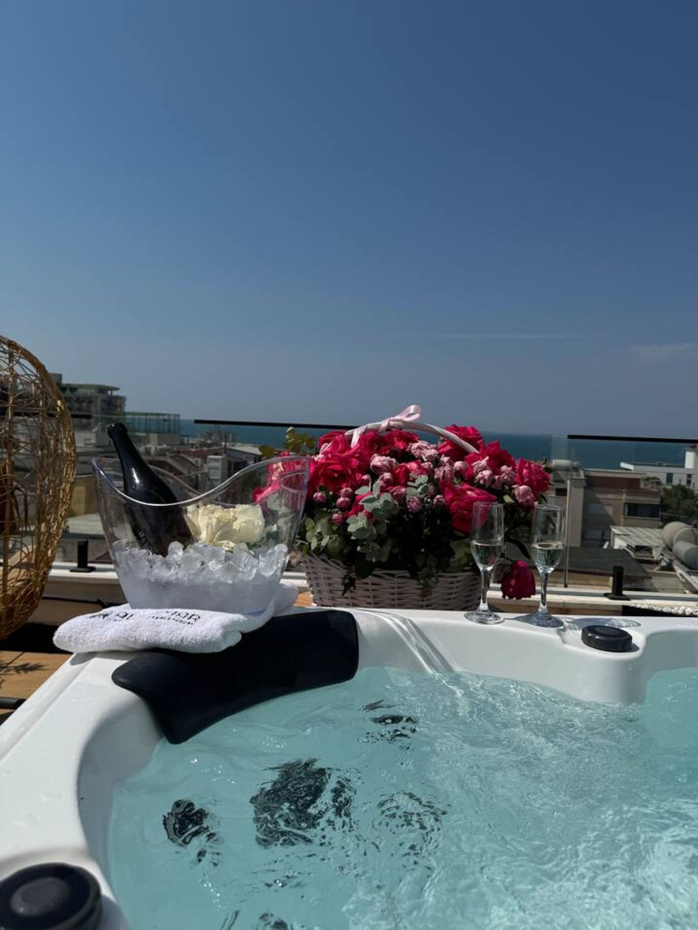Jacuzzi con hielo y flores en una terraza en la azotea, con vistas a la ciudad.