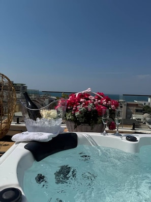 Jacuzzi con hielo y flores en una terraza en la azotea, con vistas a la ciudad.