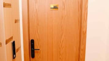 Een houten deur met een nummerbord waarop kamer 103 staat.