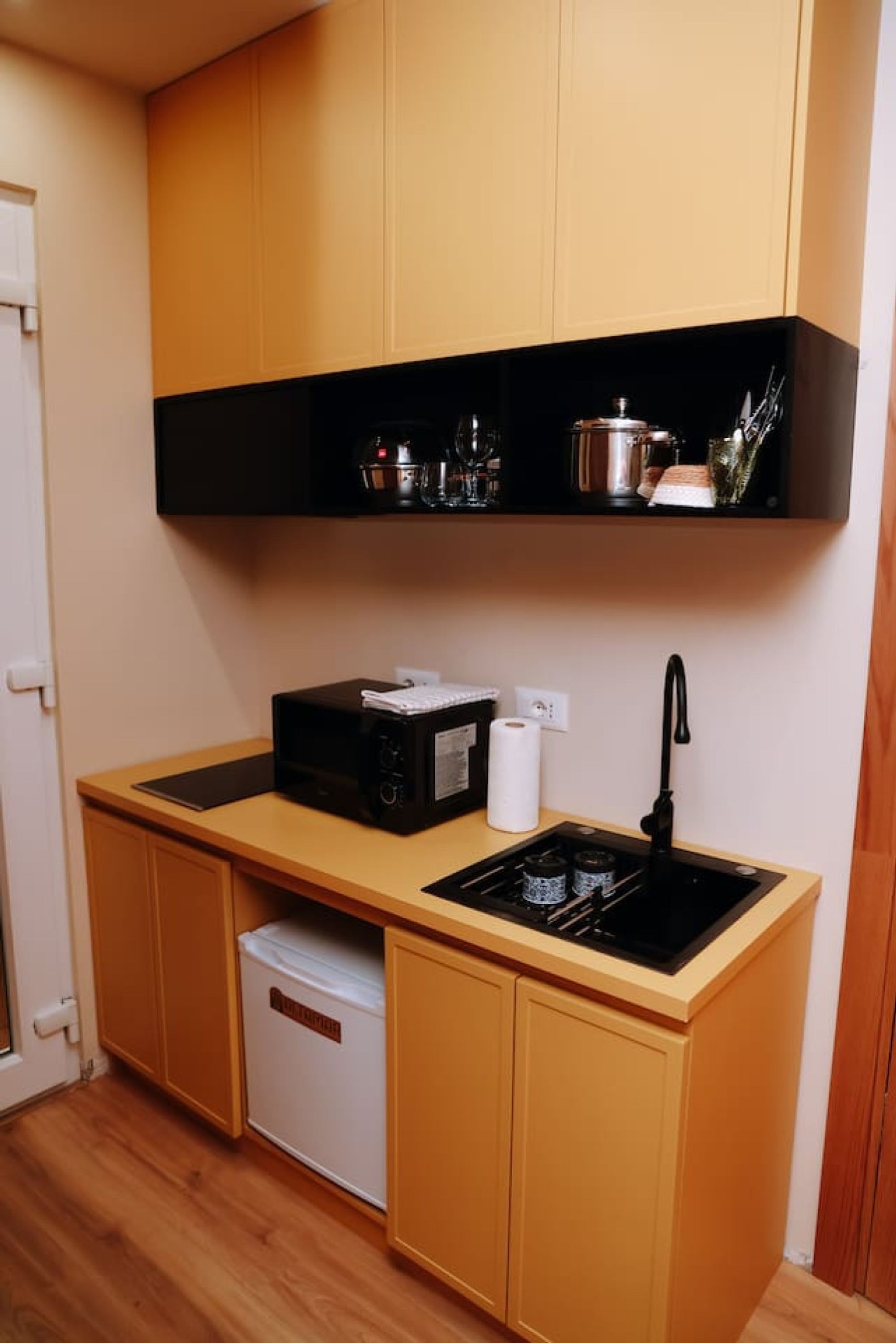 Eine kleine Küche mit einer Mikrowelle, einem Toaster und einem Spülbecken.