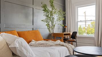 A bedroom with a bed, a desk, and a chair.