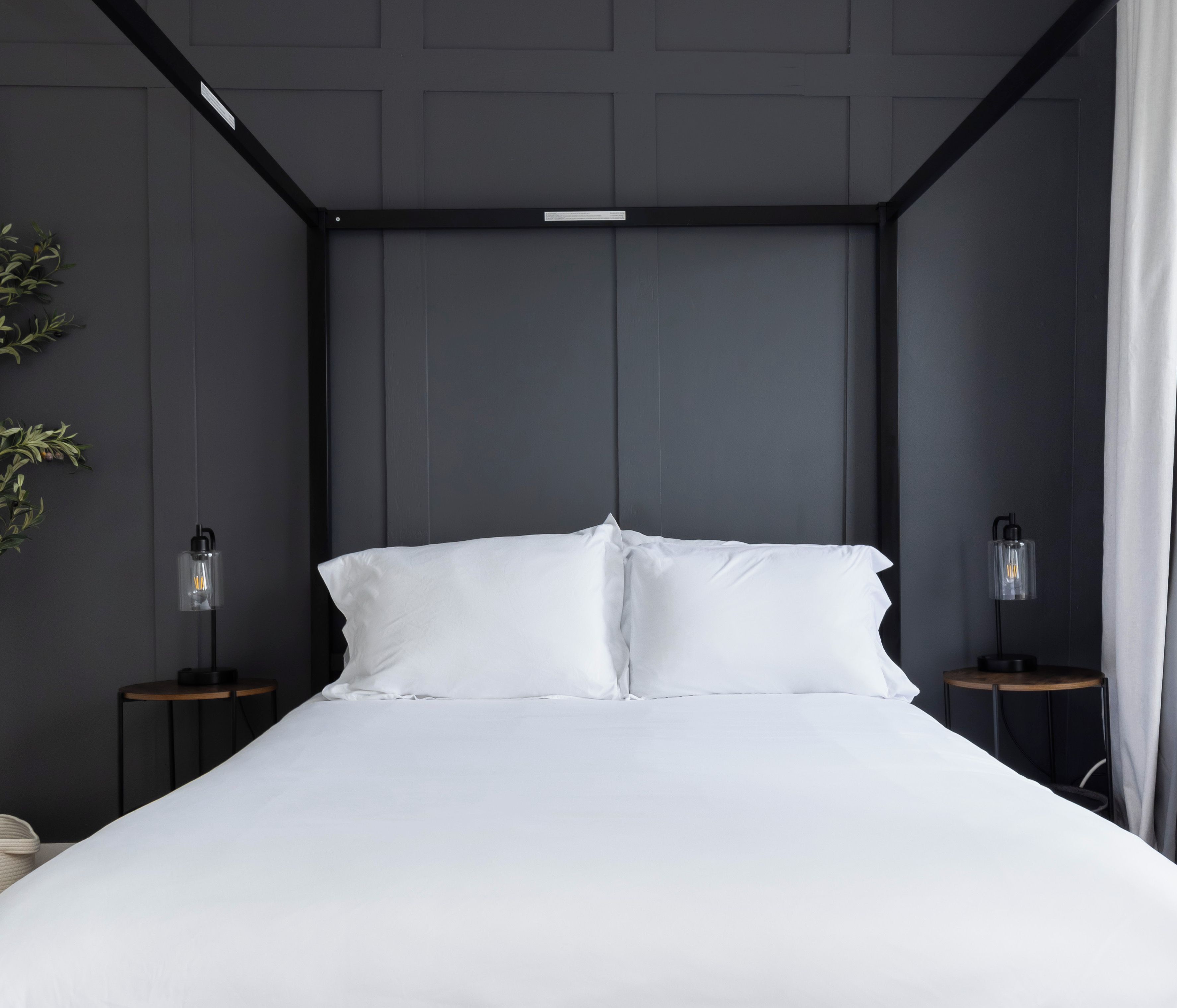 Una camera da letto moderna con un letto grande, due comodini e una lampada a sospensione.
