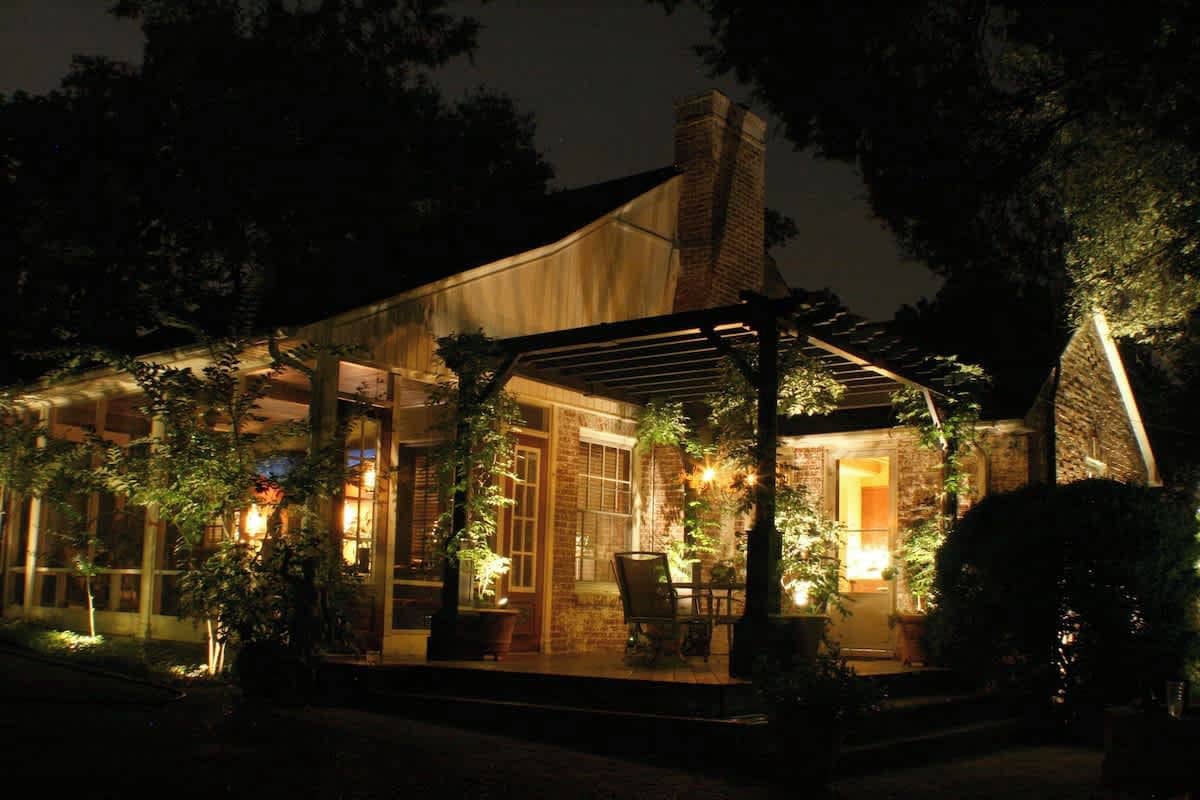 A building with a covered patio area, large windows, and outdoor seating.
