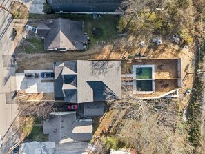 An aerial view of a residential area with multiple houses, a swimming pool, and a small parking area. - Nashville home with game room and home theater! (Nashville)