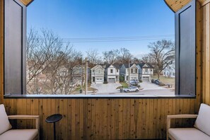 A room with a large window offering a view of a row of townhouses. - Nashville home with game room and home theater! (Nashville)