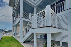 A multi-level building with a covered outdoor area and a staircase. - Klose Enough (Kure Beach)