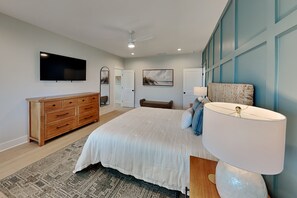 A bedroom with a large bed, a dresser, a television, and a ceiling fan. - Klose Enough (Kure Beach)