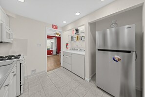 Eine moderne Küche mit einem Edelstahl-Kühlschrank, einem Herd und einer Waschmaschine.