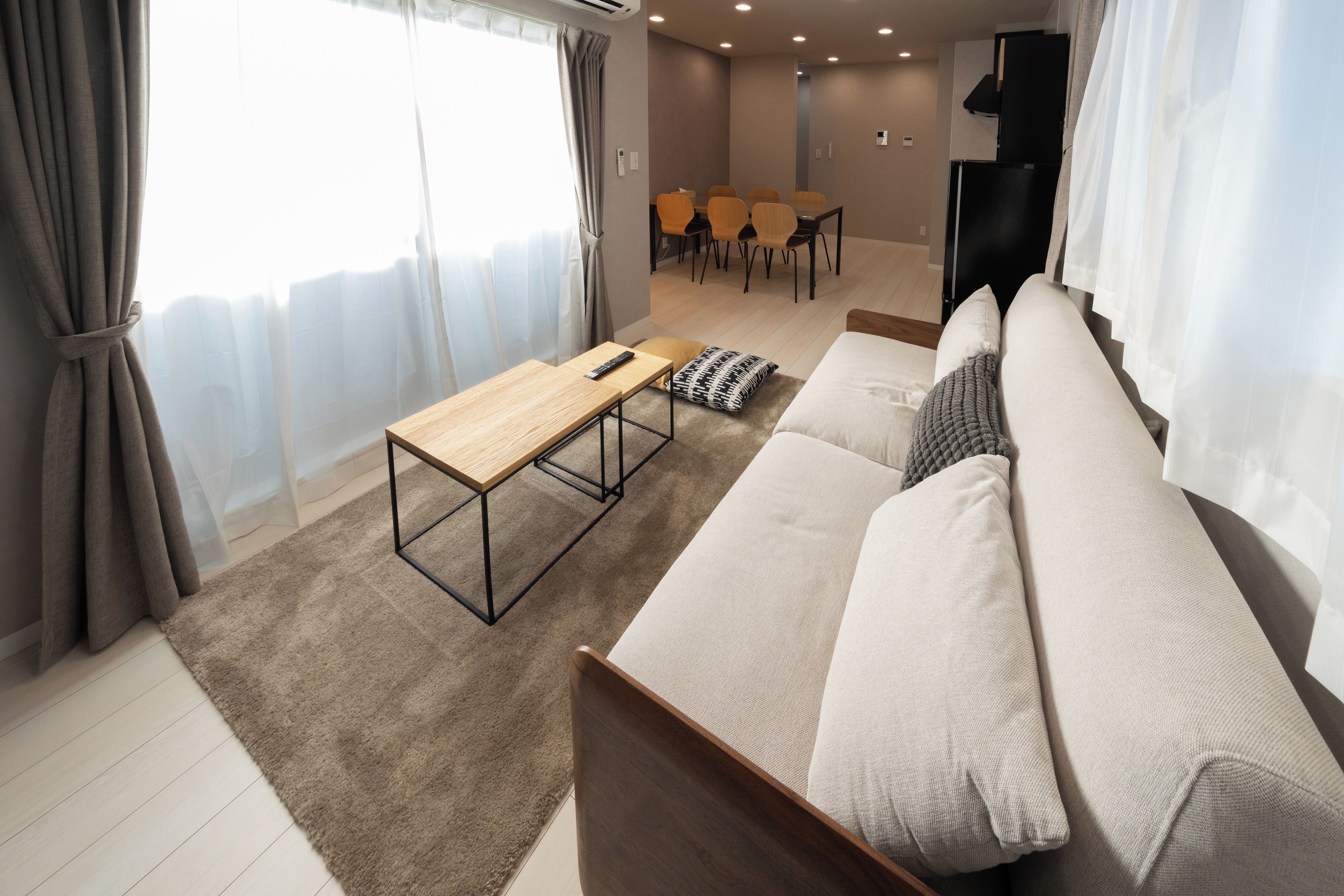Ein modernes Wohnzimmer mit einer Couch, einem Couchtisch aus Holz und einem Essbereich mit Stühlen.