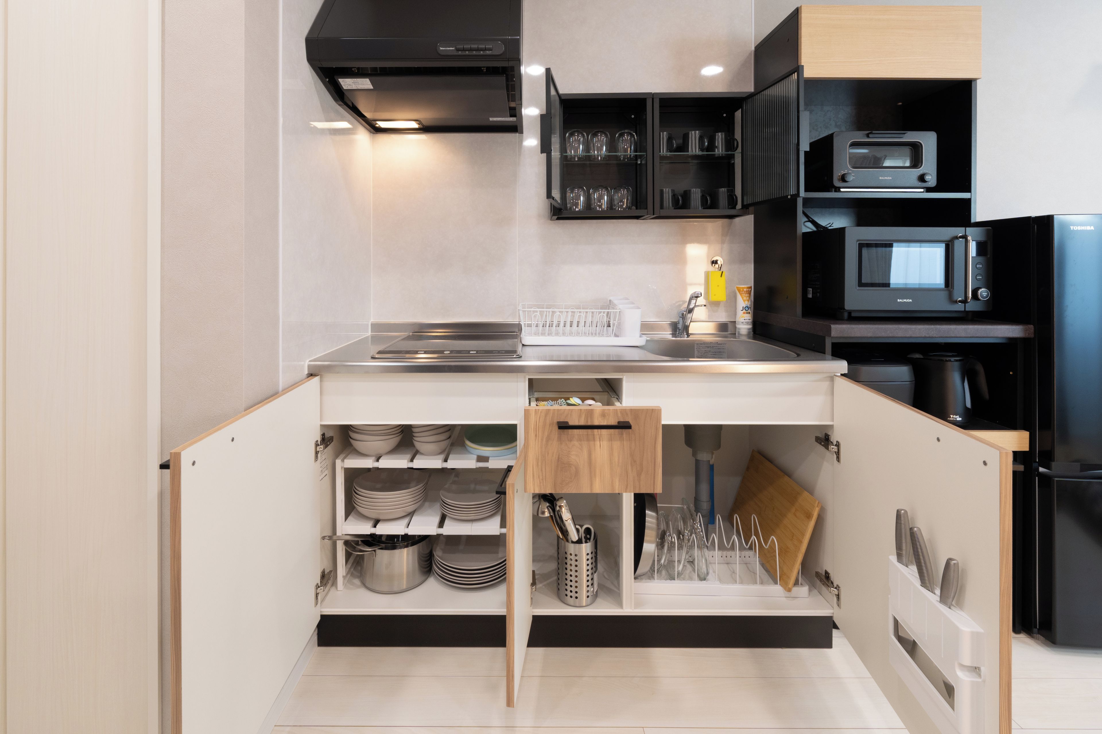 A modern kitchen with built-in appliances, a microwave, and a range hood.