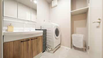 Un baño moderno con lavadora incorporada, un espejo y un perchero para toallas.