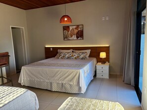 Ein Schlafzimmer mit einem großen Bett, Nachttischen, einer Hängelampe und einem Wandbild.