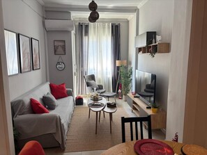 A modern living room with a sofa, armchairs, a coffee table, and a TV. - Apartment 'George House' with Balcony, Wi-Fi and Air Conditioning (Θεσσαλονίκη)