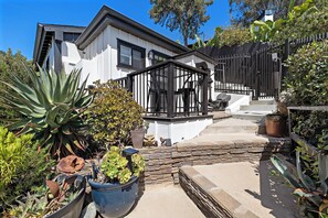 A modern house with a white exterior, a black metal fence, and various potted plants. - Private Ocean-View Guest Casita, South Laguna Beach (Laguna Beach)