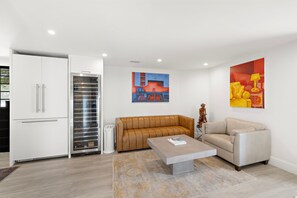 A modern living room with a sofa, a coffee table, and a painting on the wall. - Private Ocean-View Guest Casita, South Laguna Beach (Laguna Beach)