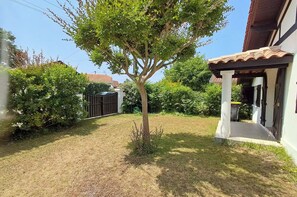 A residential property with a well-maintained lawn, a tree, a gated entrance, and a building with a tiled roof. - Family home 500 meters from the beach, sleeps 6 (Andernos-les-Bains)