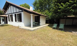 A two-story building with a balcony, a covered patio area, and a grassy yard. - Family home 500 meters from the beach, sleeps 6 (Andernos-les-Bains)