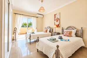Ein Hotelzimmer mit zwei Betten, einem Balkon und einem Gemälde an der Wand.