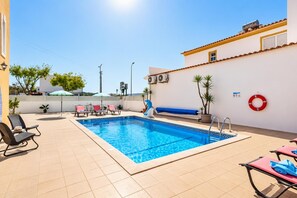 A swimming pool with lounge chairs and a slide, surrounded by a white wall and a tiled floor. - Villa Girassol - Three Bedroom Villa, Sleeps 6 (Vale Rebelho)