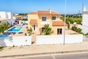 A two-story house with a swimming pool, a red door, and a white fence. - Villa Girassol - Three Bedroom Villa, Sleeps 6 (Vale Rebelho)
