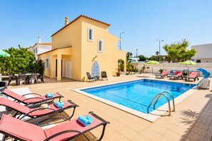 A pool area with lounge chairs, a small building, and a clear blue sky. - Villa Girassol - Three Bedroom Villa, Sleeps 6 (Vale Rebelho)