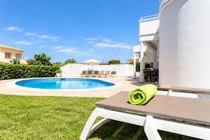 A pool area with a clear blue pool, lounge chairs, and a neatly rolled towel. - Villa Silva Balbina - Four Bedroom Villa, Sleeps 8 (Albufeira)