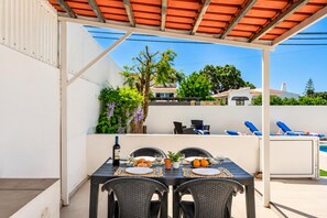 An outdoor patio with a table set for two, chairs, a bottle of wine, and a plate of food. - Villa Dela - Two Bedroom Villa, Sleeps 4 (Vale Rebelho)