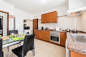 A modern kitchen with wooden cabinets, a stainless steel oven, and a granite countertop. - Villa Dela - Two Bedroom Villa, Sleeps 4 (Vale Rebelho)