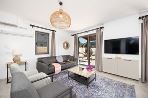 A modern living room with a sofa, armchair, coffee table, and a TV. - Villa Lidya - Five Bedroom Villa, Sleeps 10 (Dalyan)