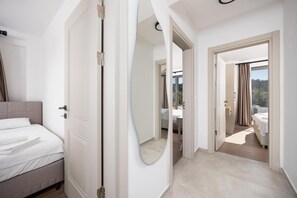 Een hotelkamer met een bed, een spiegel en uitzicht op een balkon met een tafel en stoelen.