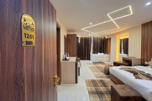 Habitació d'hotel moderna amb una paret decorativa de fusta, un llit, un escriptori i un bany amb banyera.