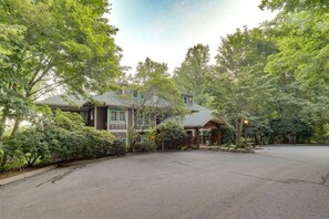 A two-story house with a covered porch, surrounded by lush greenery. - Mtn-View Condo w Private Balcony in Burnsville (Burnsville)