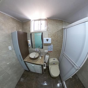 A compact bathroom with a sink, toilet, and a mirror above the sink. - Apartamentos Aury (San Andrés)